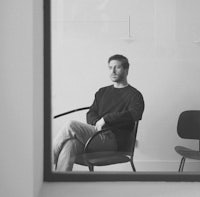 a man sitting in a chair in front of a window