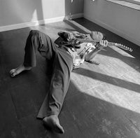 a man laying on the floor with a guitar